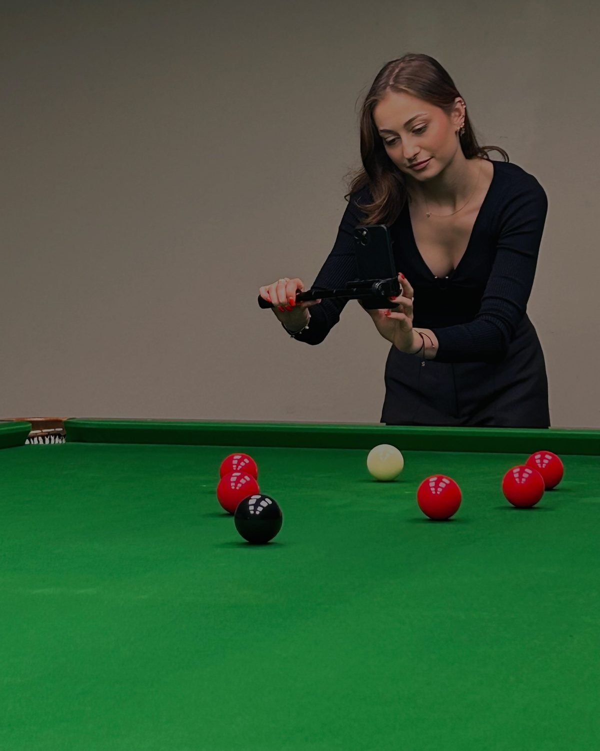 Aleksandra Wróblewska nagrywa telefonem na gimbalu przy stole snookerowym